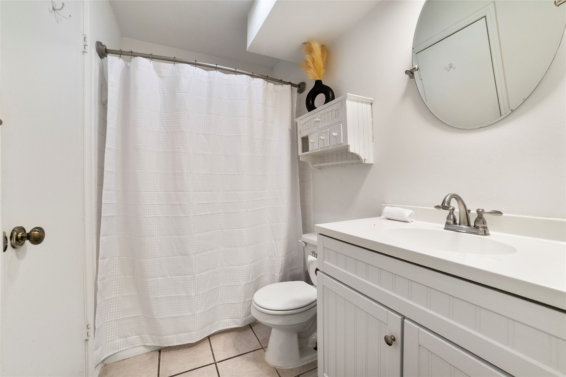 2009 Kenneth Avenue, Unit A Austin, TX 78741 - Photo 13 of 17 a bathroom with a sink a toilet and a mirror