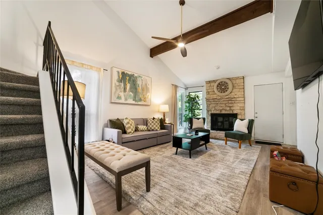 a living room with furniture a flat screen tv and a fireplace