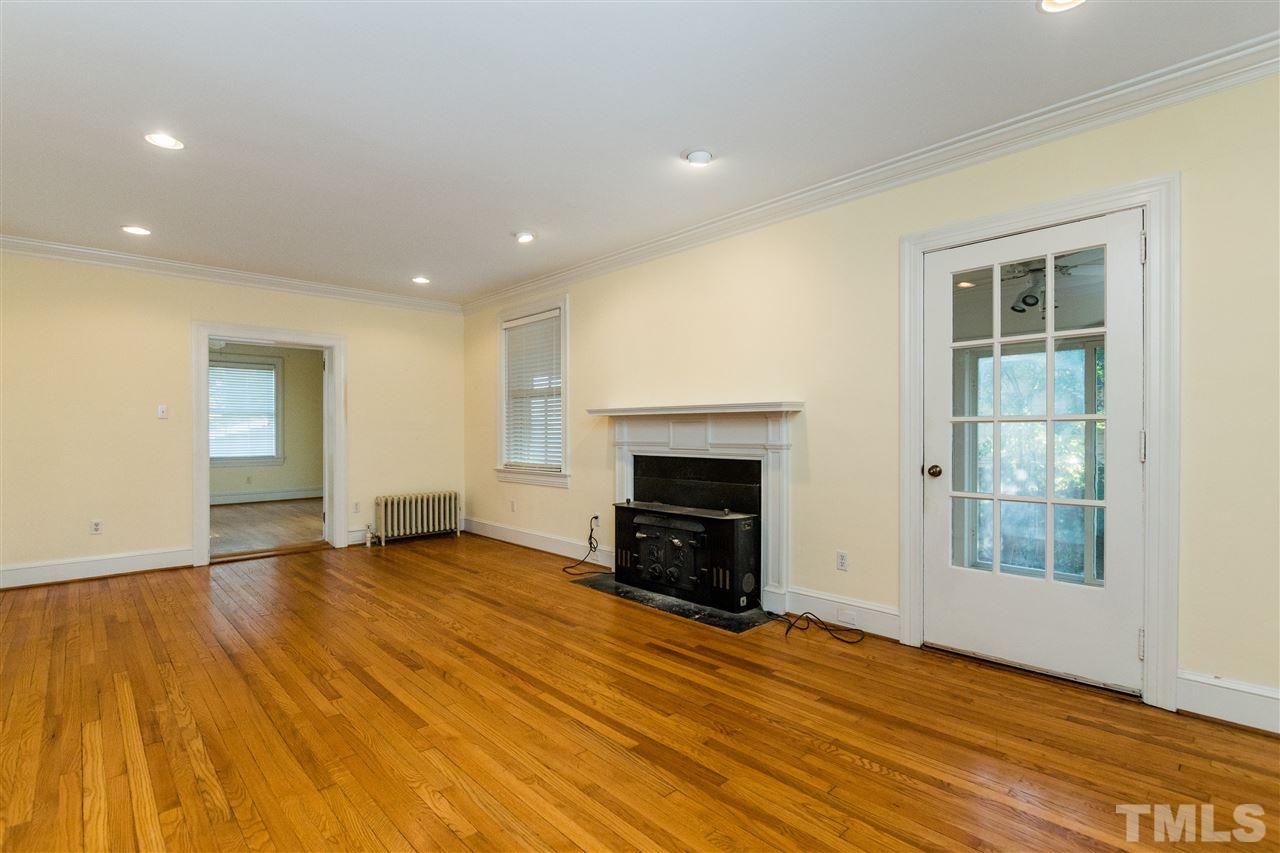 509 Burton Street Raleigh, NC 27608 - Photo 5 of 25 a view of empty room with wooden floor and fireplace