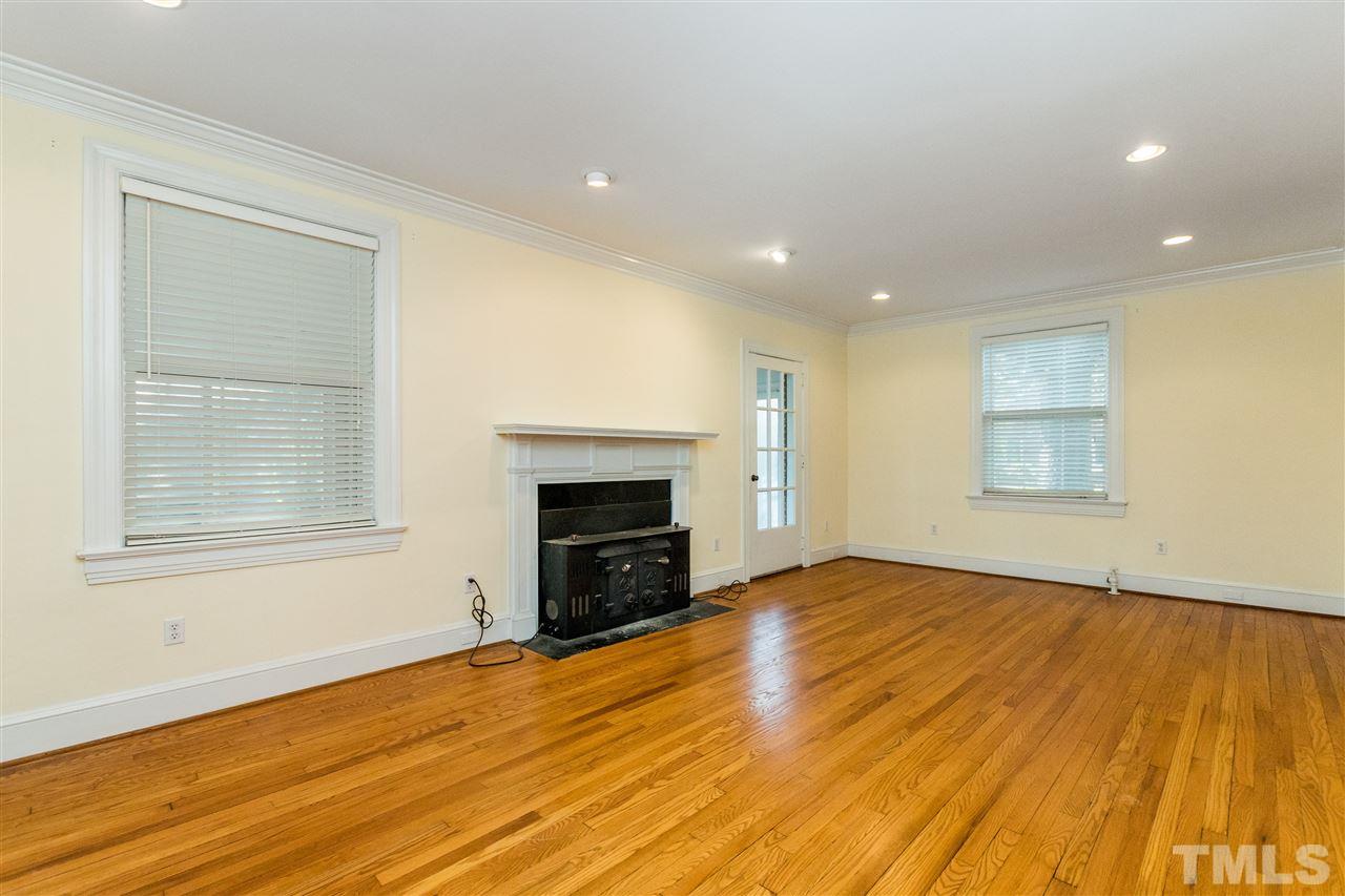 509 Burton Street Raleigh, NC 27608 - Photo 6 of 25 a view of empty room with wooden floor and fireplace