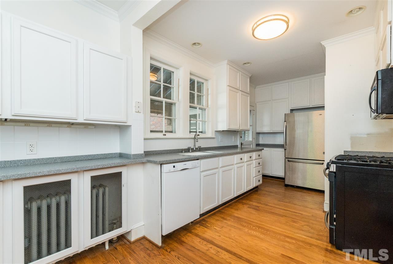 509 Burton Street Raleigh, NC 27608 - Photo 8 of 25 a kitchen with granite countertop white cabinets and white appliances