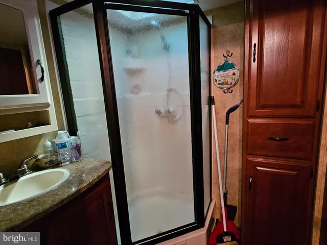 a bathroom with mirror and shower