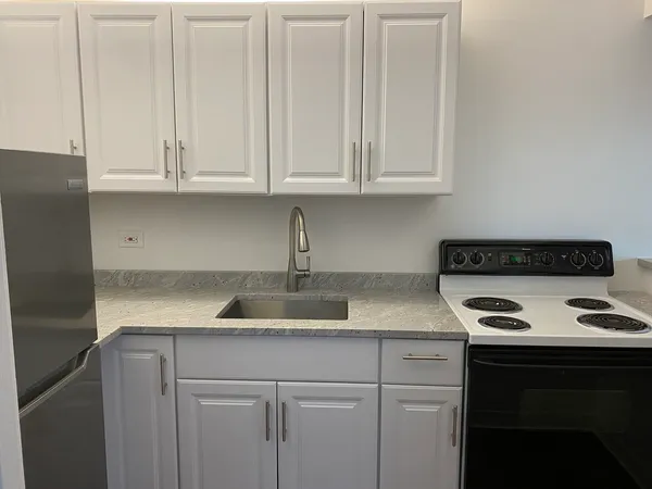 a kitchen with granite countertop white cabinets and a sink