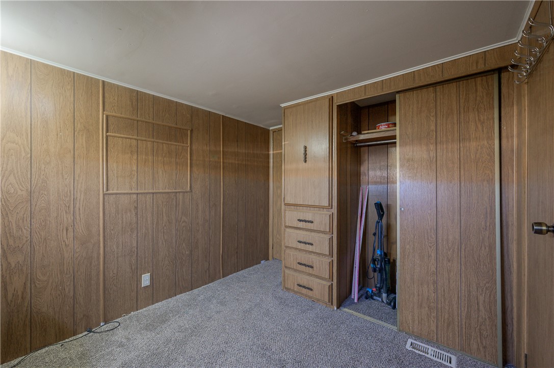 1798 Rio Grande Way Bullhead City, AZ 86442 - Photo 26 of 43 Bedroom featuring a closet, carpet flooring, and wood walls