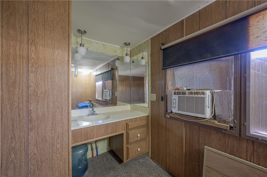 1798 Rio Grande Way Bullhead City, AZ 86442 - Photo 27 of 43 Bathroom with wood walls, dark colored carpet, vanity, and ornamental molding