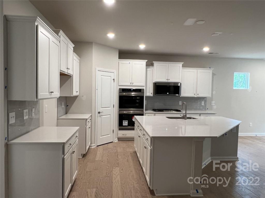 3159 Windhaven Lane, Unit 81 Tega Cay, SC 29708 - Photo 3 of 6 a large kitchen with kitchen island a sink stainless steel appliances and cabinets