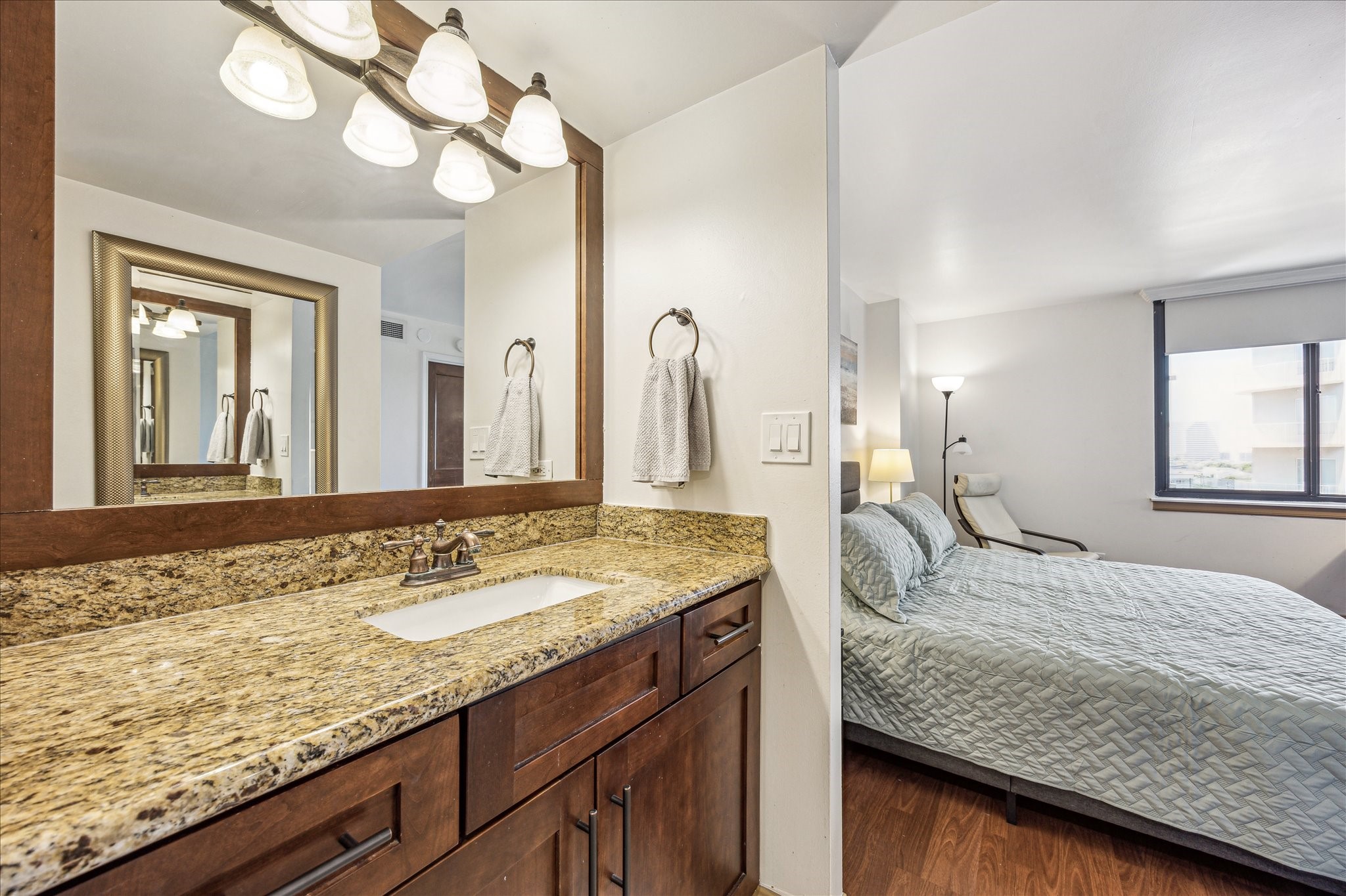 3525 Sage Road, Unit 1010 Houston, TX 77056 - Photo 21 of 34 Primary bathroom has granite countertops, wall mounted framed mirror and lighting above.