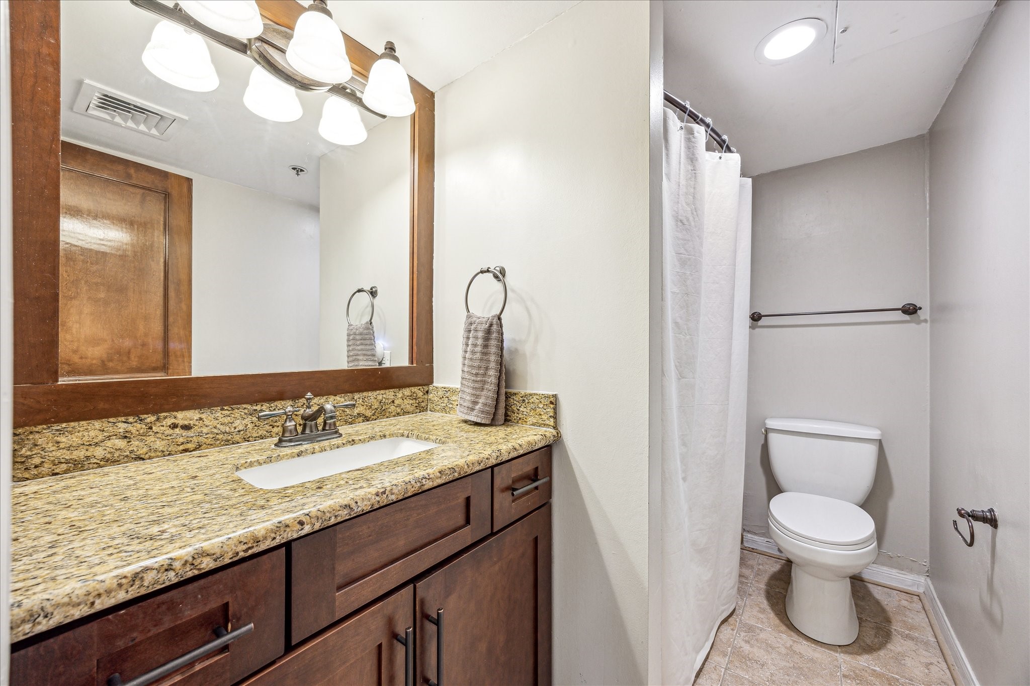 3525 Sage Road, Unit 1010 Houston, TX 77056 - Photo 26 of 34 Conveniently located off the foyer is the second full bathroom including granite countertops, a wall mounted mirror with lighting, and a tub in shower.
