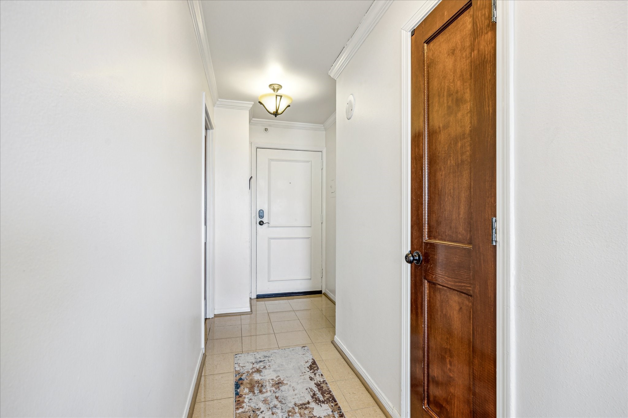 3525 Sage Road, Unit 1010 Houston, TX 77056 - Photo 5 of 34 The foyer welcomes you with elegant crown moulding, double pendant lights, a convenient coat closet, and tile flooring.