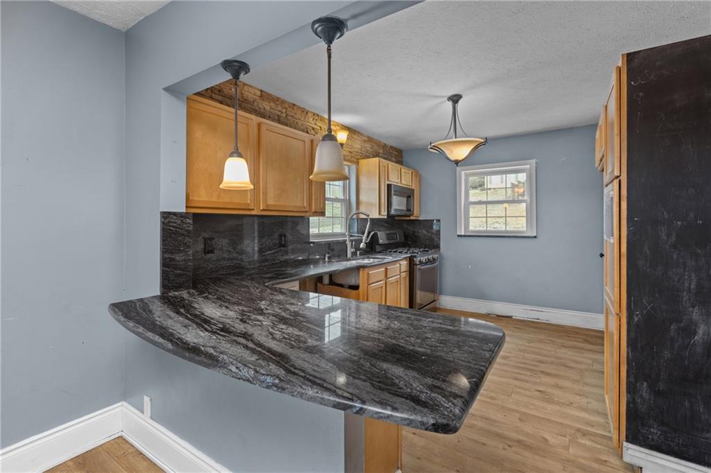 41 Bethlehem Street Fredericktown, PA 15333 - Photo 13 of 33 a kitchen with stainless steel appliances granite countertop a sink a stove top oven a counter space and cabinets