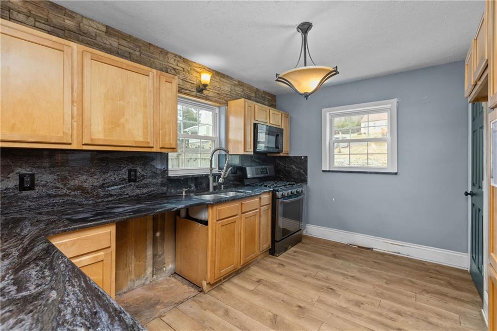 41 Bethlehem Street Fredericktown, PA 15333 - Photo 14 of 33 a kitchen with stainless steel appliances granite countertop a sink a stove a refrigerator cabinets and a window