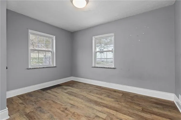 a view of a room with wooden floor and windows