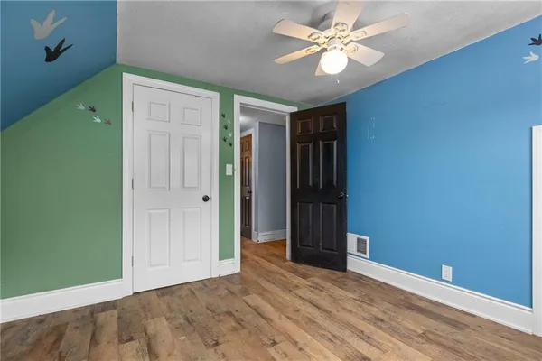an empty room with closet and a ceiling fan