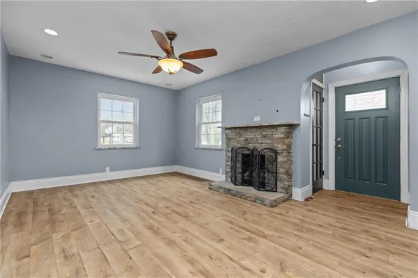 a view of an empty room with window and fireplace