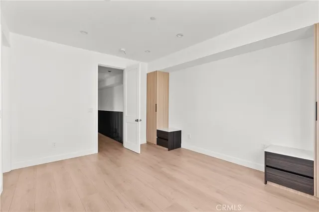 a view of a room with wooden floor and a bathroom
