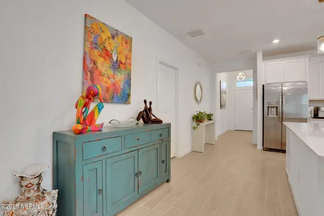 a large white kitchen with stainless steel appliances kitchen island granite countertop a large island in the center