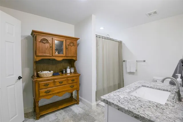 a bathroom with a granite countertop sink and a mirror