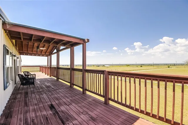 a view of a balcony with furniture and wooden floor