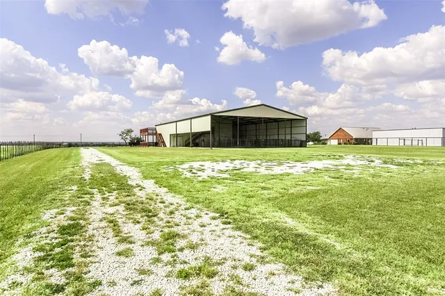 a view of a house with a big yard and a large tree