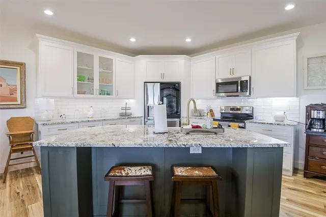 a kitchen with granite countertop stainless steel appliances and sink