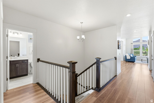 108 West Monte Rosa Lane Midway, UT 84049 - Photo 24 of 48 Hallway with wood-finish flooring, white walls, and a dark wood and white baluster staircase