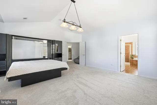 a spacious bedroom with a bed a window and couch