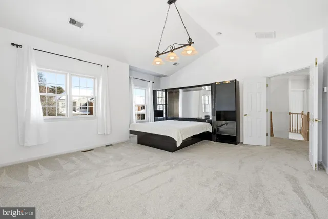 a spacious bedroom with a bed and a window