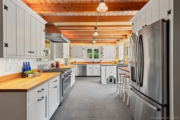 a kitchen with stainless steel appliances a refrigerator sink and cabinets