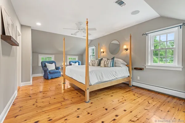 a bedroom with a bed lamp and a large window
