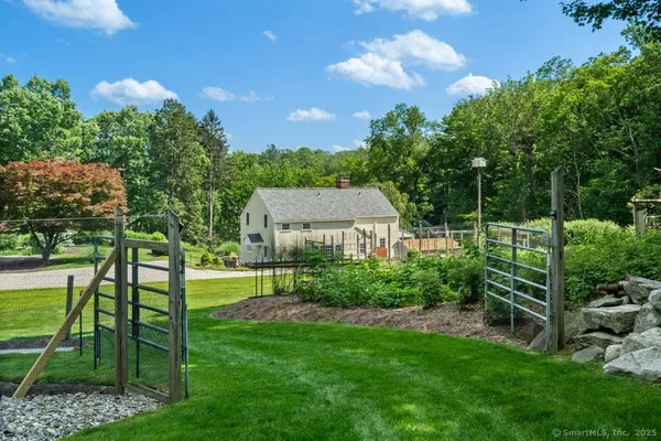 a view of a chair and table in the garden and trees