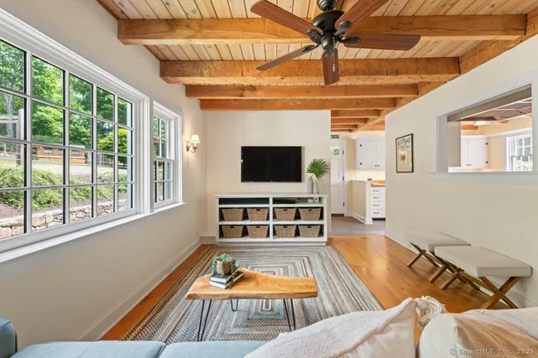 a living room with furniture flat screen tv and a large window