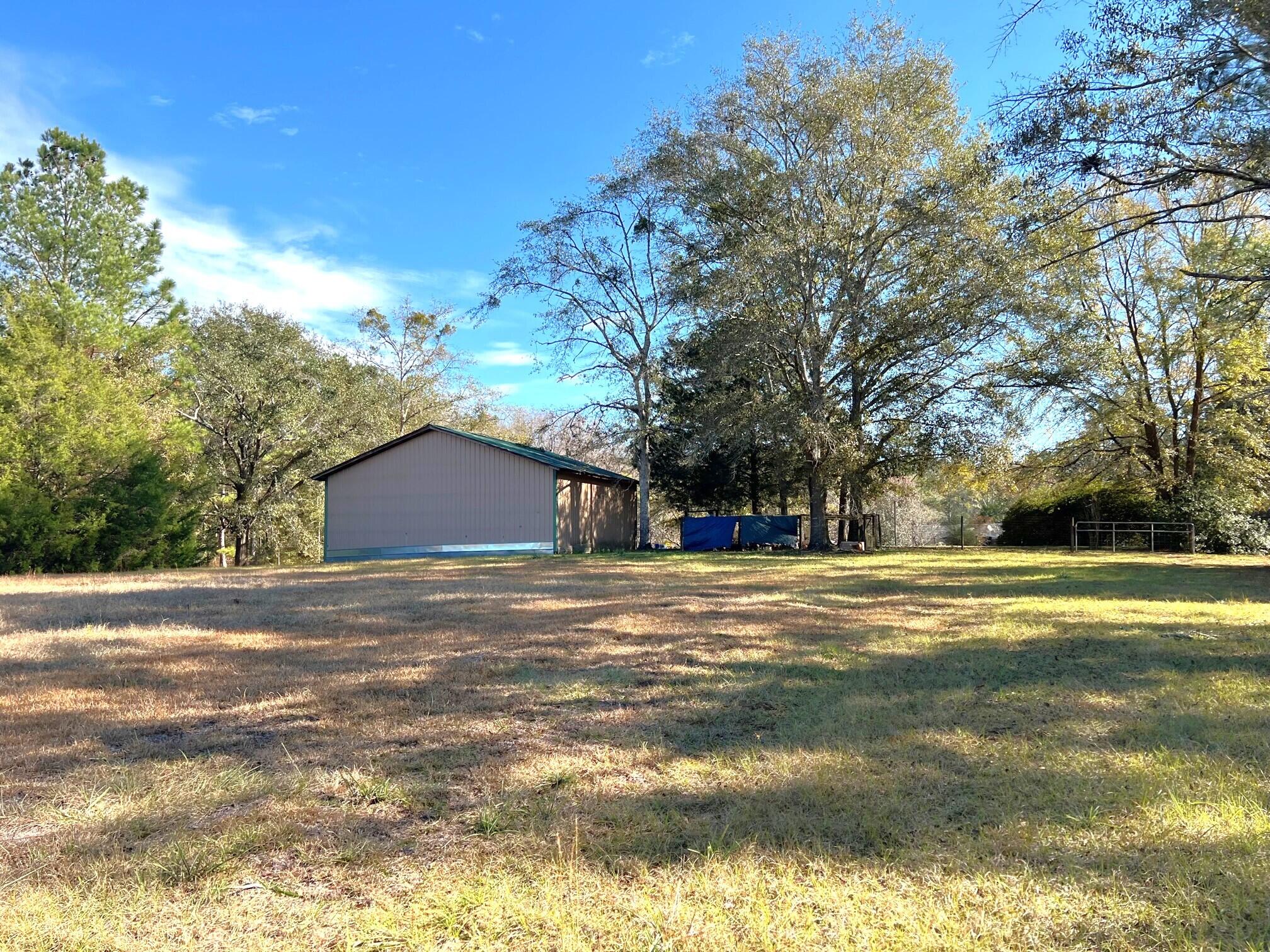 401 Mims Road DeFuniak Springs, FL 32433 - Photo 44 of 78 a tall yellow house with trees in the background