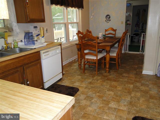 172 Windjammer Road Ocean Pines, MD 21811 - Photo 6 of 24 a kitchen with stainless steel appliances kitchen island granite countertop a sink table and chairs