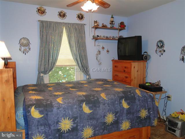 172 Windjammer Road Ocean Pines, MD 21811 - Photo 10 of 24 a bedroom with a bed and a chandelier