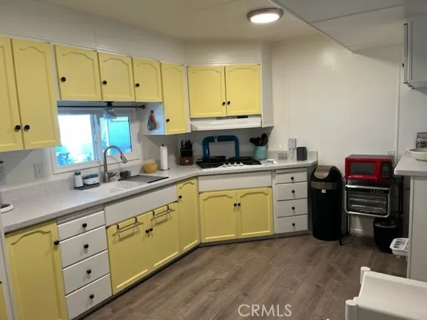 a kitchen with granite countertop a sink cabinets and stainless steel appliances
