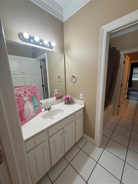 201 Woodhaven Drive Minden, LA 71055 - Photo 19 of 31 Bathroom featuring a white vanity with integrated sink, white tiled flooring, and crown molding