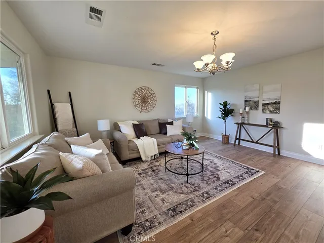 a living room with furniture chandelier and a table