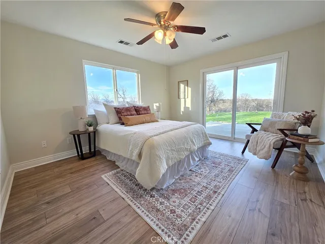 a bedroom with a bed and large windows