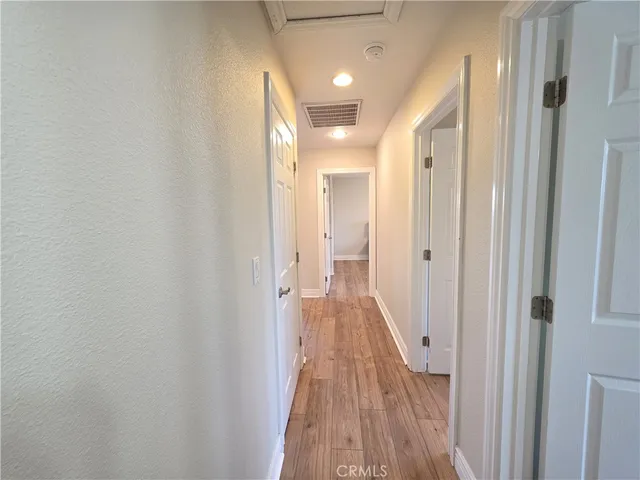 a view of a hallway with wooden floor