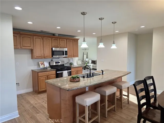 a kitchen with granite countertop a table chairs microwave and cabinets