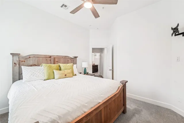 a bedroom with a bed and a ceiling fan