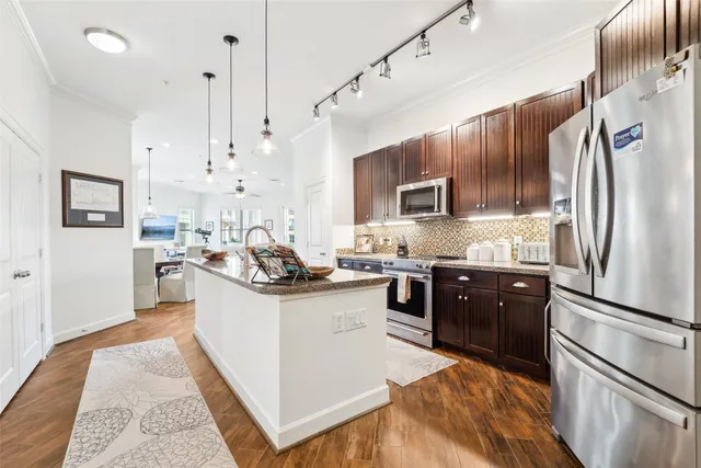 a kitchen with stainless steel appliances granite countertop a sink stove and refrigerator