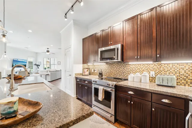 a kitchen with stainless steel appliances granite countertop a sink a stove and a microwave
