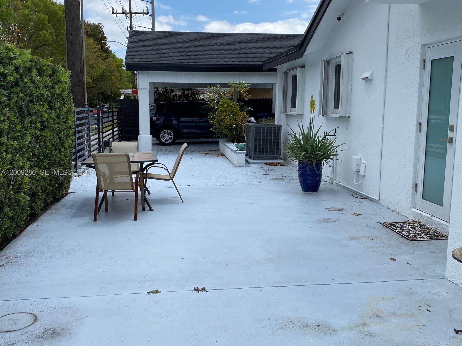 403 Southwest 89th Place Miami, FL 33174 - Photo 2 of 39 a view of a patio with table and chairs potted plants and floor to ceiling window