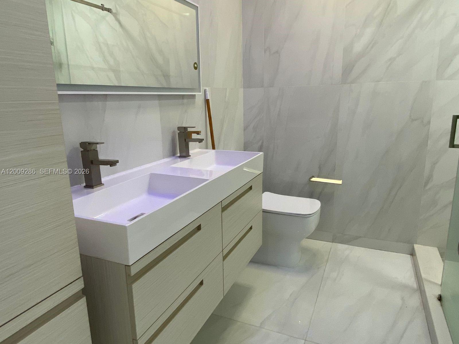 403 Southwest 89th Place Miami, FL 33174 - Photo 21 of 39 a bathroom with a sink a toilet and vanity