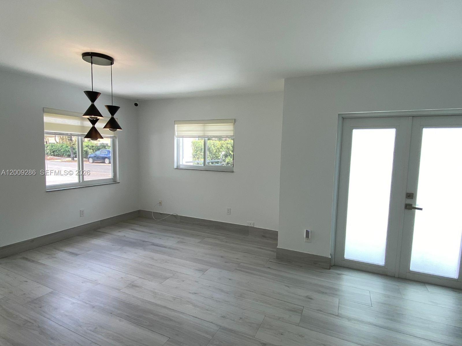 403 Southwest 89th Place Miami, FL 33174 - Photo 4 of 39 a view of an empty room with a window and wooden floor