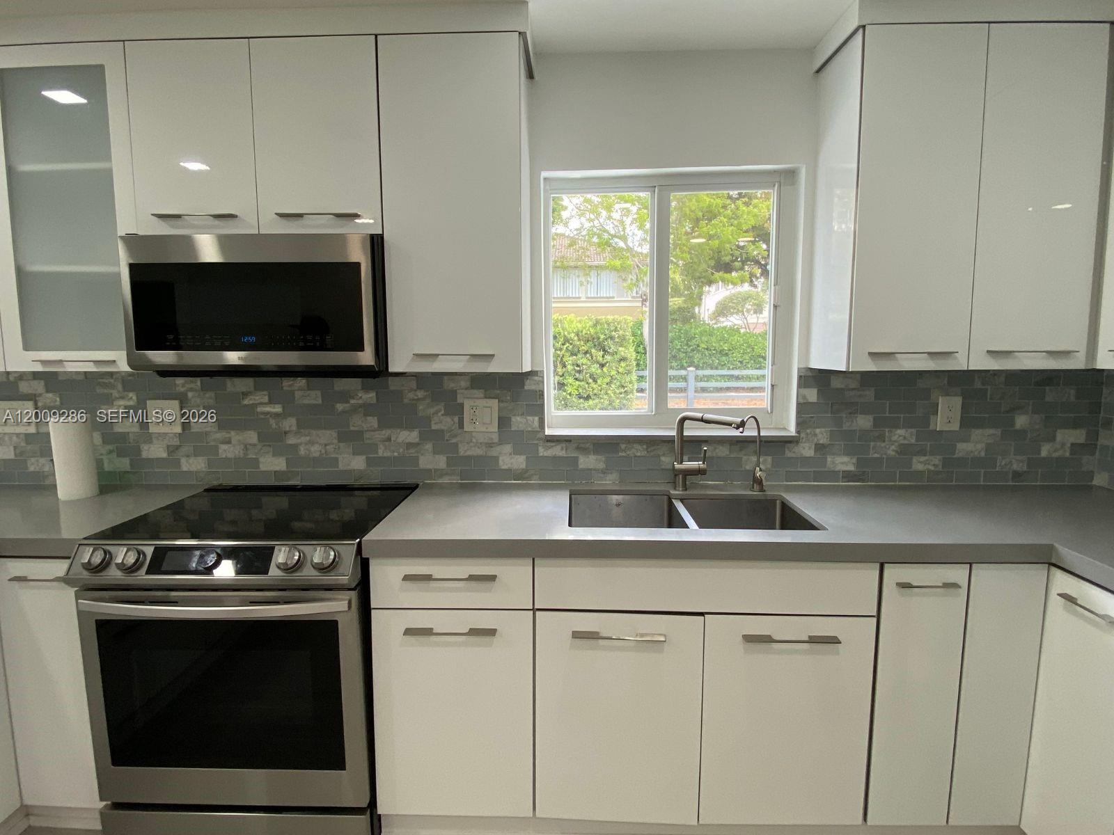 403 Southwest 89th Place Miami, FL 33174 - Photo 10 of 39 a kitchen with a stove and a microwave
