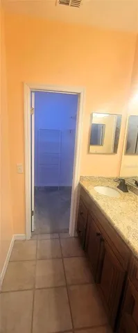 a bathroom with a granite countertop sink and washing machine
