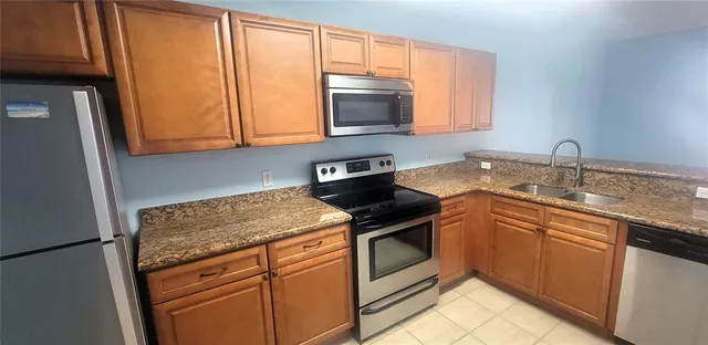 a kitchen with stainless steel appliances granite countertop a sink stove and microwave