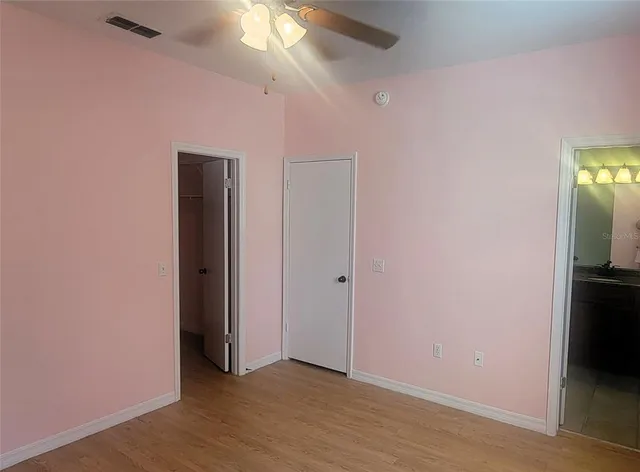 an empty room with wooden floor and closet